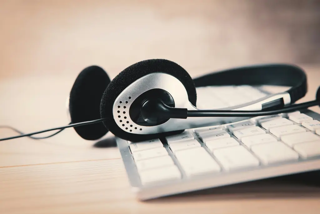 Un par de auriculares encima de un teclado de Mac